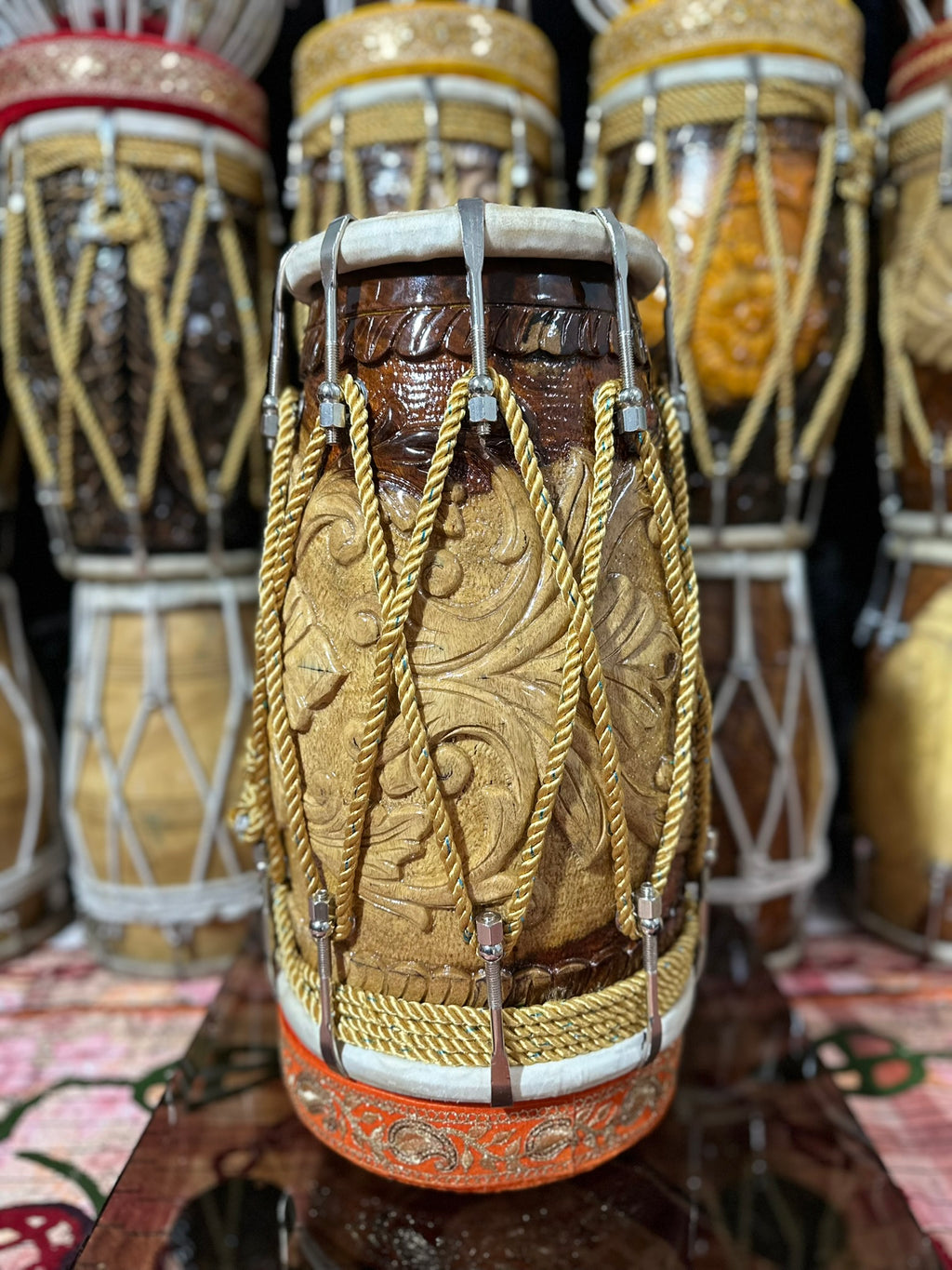 Decorative drum with intricate patterns and gold accents on a patterned surface.